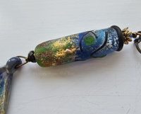 Artisan pendant includes this stunning lampwork bead in shades of green, blue, yellow, red and black