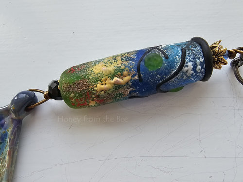 Artisan pendant includes this stunning lampwork bead in shades of green, blue, yellow, red and black