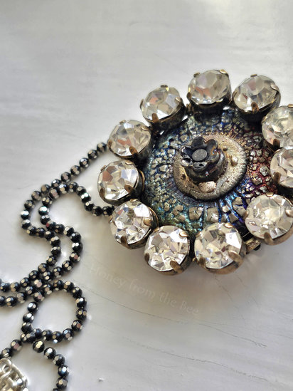 Eclipse pendant features ceramic, antique rhinestone buckle and sterling silver