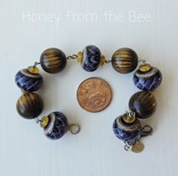 Golden brown and purple bracelet features wood beads and lampwork