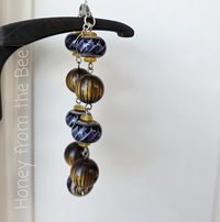 Purple ribbon bracelet features lampwork and wood beads