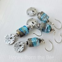 Beach earrings feature sand dollar charms and lampwork