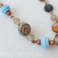 orange and blue bracelet features lampwork bead