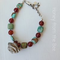 Green and orange bracelet features sterling silver rose