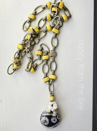 Black and yellow necklace is tunic length and features daisy motif