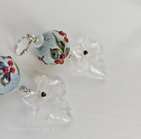 Winter season earrings feature holly lampwork and frosty glass leaves