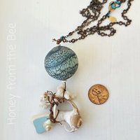 Special beach pendant features lampwork and found shells
