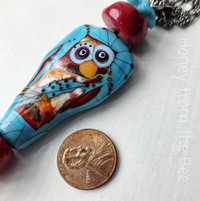 Statement necklace features owl in red and turquoise