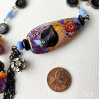 Purple, orange and blue necklace features crow lampwork