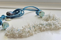 Beach necklace features a beadwoven surf in crystal and white beads