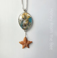 Sterling silver pendant features plume agate and starfish dangle