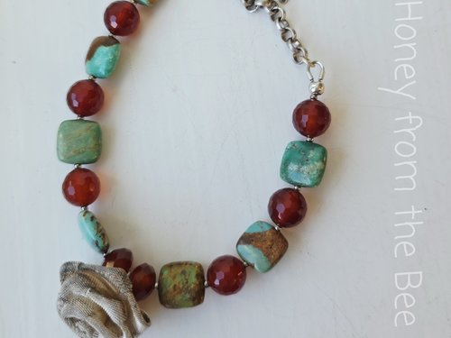 Green and orange bracelet features sterling silver rose