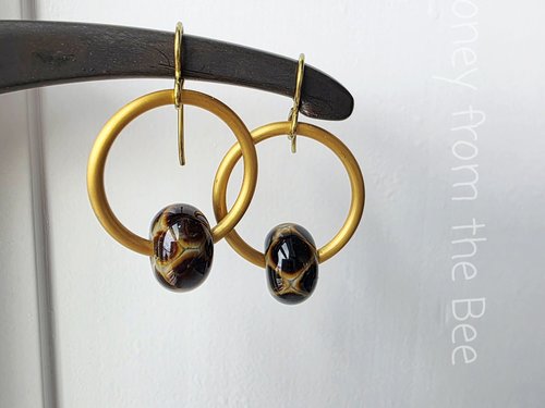 Animal print earrings feature giraffe print lampwork and gold hoops