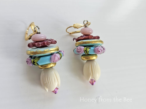 Floral earrings feature lampwork in shades of pink, aqua and gold