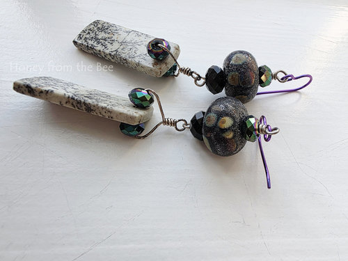Statement earrings feature sapling jasper and raku lampwork
