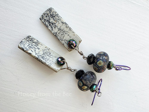Iridescent and black lampwork earrings feature jasper dangles