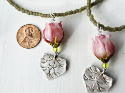 Young woman necklace features pink rosebud and silver leaf