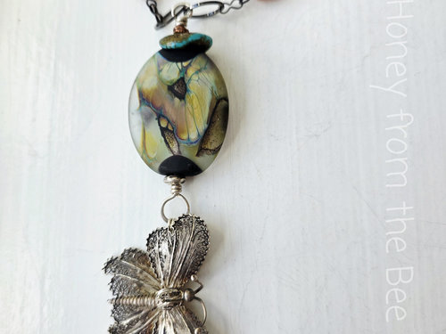 Butterfly necklace features filigree butterfly and peach moonstone