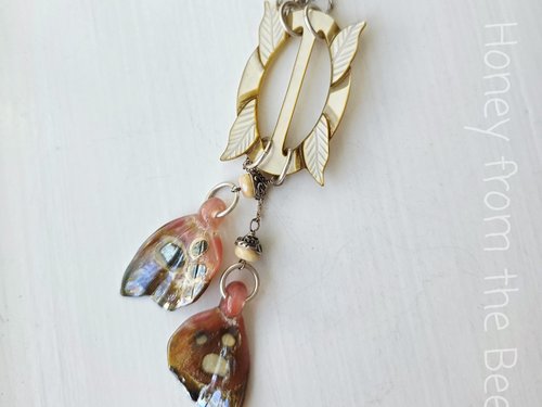 Butterfly necklace features lampworked butterfly wings in pink and an antique MOP buckle