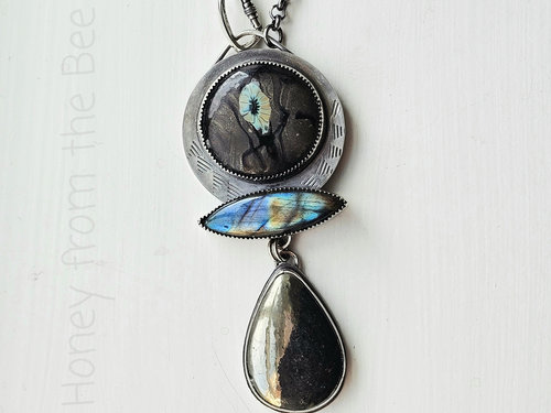Statement necklace features silver, labradorite, apache gold, and glass art cab