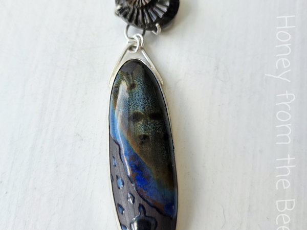 Mixed Media pendant features ceramic and ammonite set in sterling silver