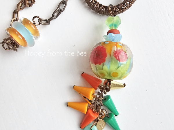 Flower themed necklace features bright colored lampwork and vintage materials.