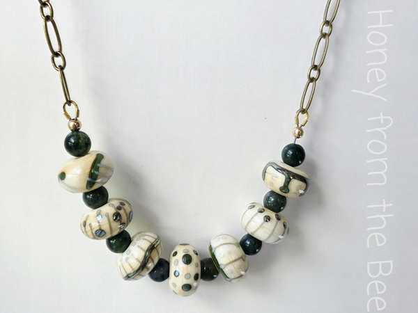 Green and white necklace features lampwork and moss agate